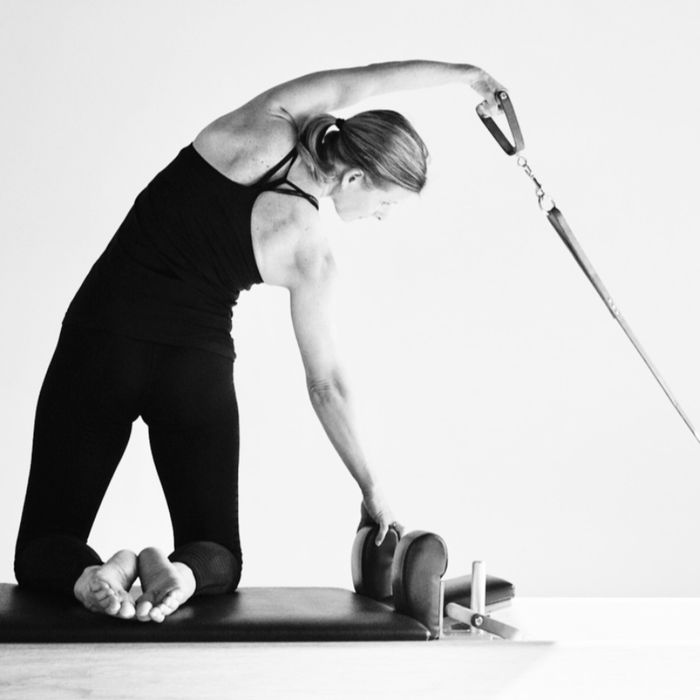 Pilates-oefening op de reformer met strap (zwartwit)